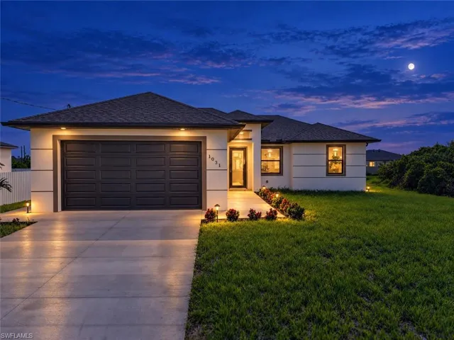 Single-story residence featuring a dark paneled garage door, a concrete driveway, and exterior wall sconces