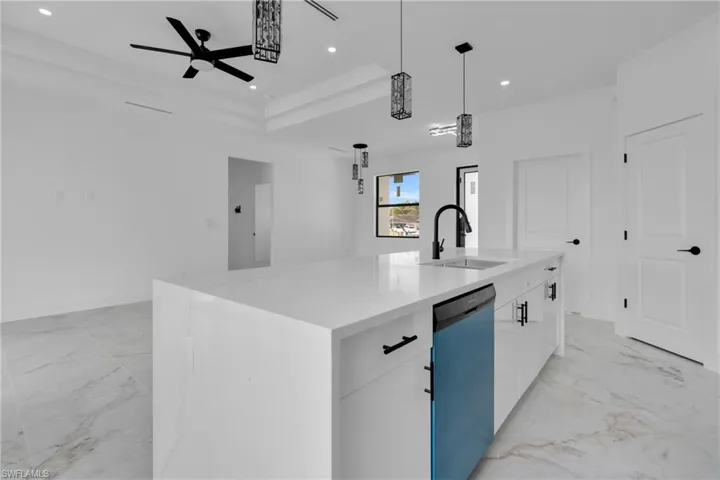 Spacious kitchen island with a white countertop and undermount sink, complemented by matte black fixtures