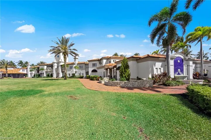 View of front of property with a front yard, stucco siding, and a tile roof