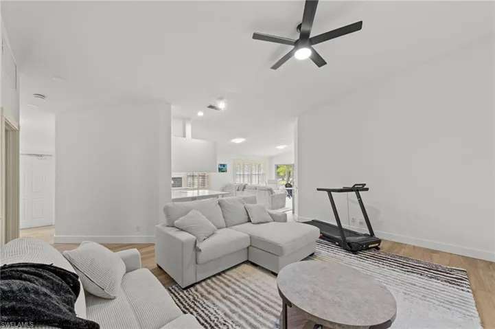 Living area with light wood finished floors, a ceiling fan, and recessed lighting