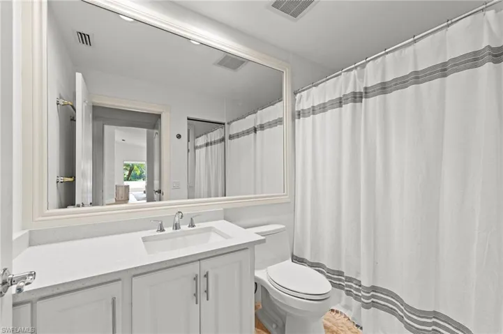 Bathroom with vanity, a shower with shower curtain, and ensuite bath