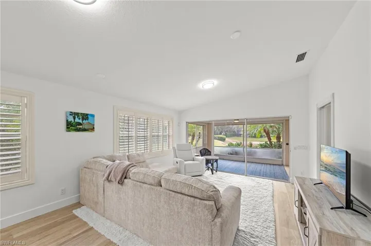 Living room featuring light wood-type flooring and lofted ceiling