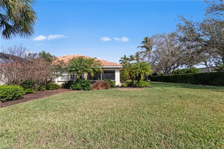 View of green lawn featuring a sunroom
