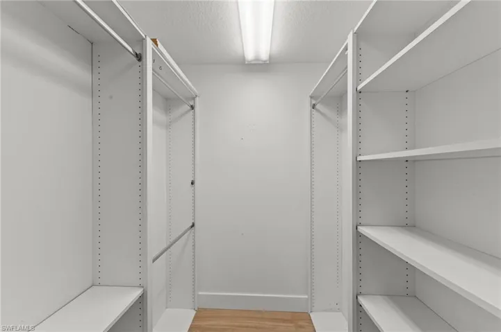 Walk in closet with light wood finished floors