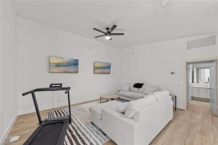 Living room with light wood finished floors and a ceiling fan