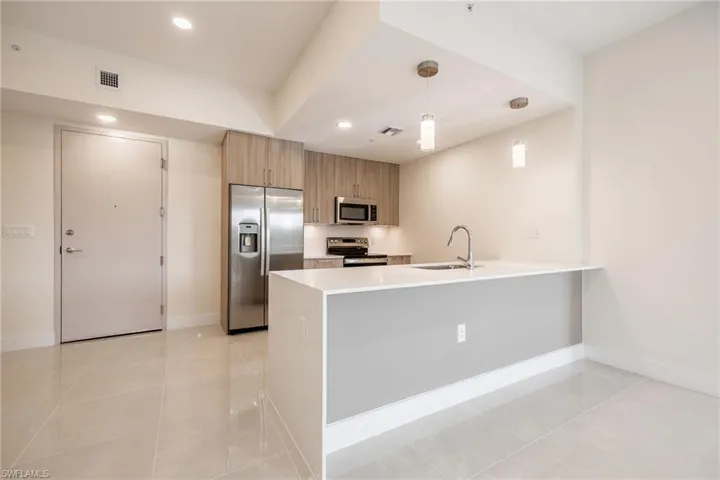 Kitchen featuring a peninsula, visible vents, a sink, and appliances with stainless steel finishes