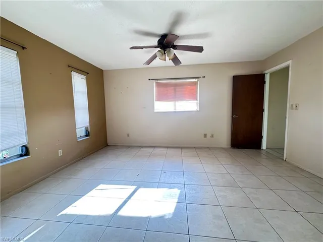 Spare room with ceiling fan and light tile patterned floors