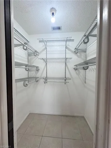 Spacious closet with light tile patterned floors