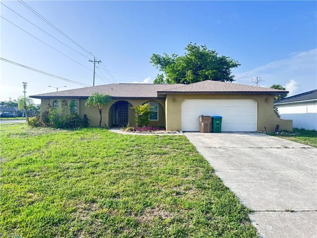 Ranch-style home featuring stucco siding, an attached garage, a front yard, and concrete driveway
