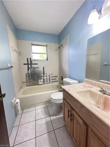 Full bathroom featuring shower / washtub combination, toilet, vanity, and tile patterned floors