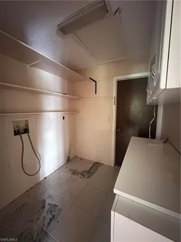 Laundry room with hookup for a washing machine, attic access, and tile patterned flooring
