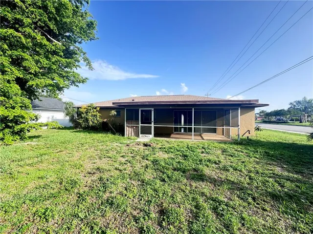 Rear view of property featuring a sunroom and a yard