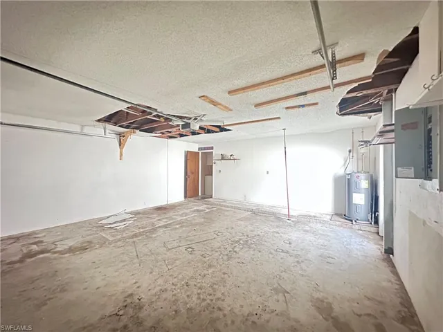Garage featuring water heater and electric panel
