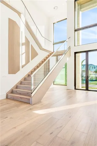 Stairs with a high ceiling and hardwood / wood-style floors