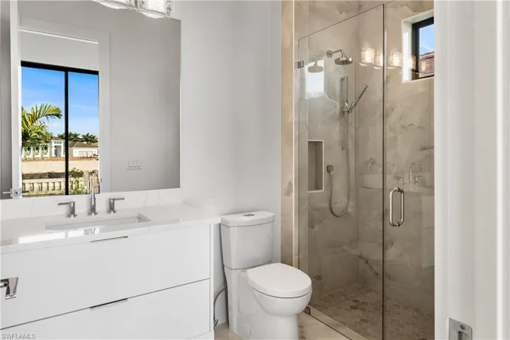 Full bath with vanity and a marble finish shower