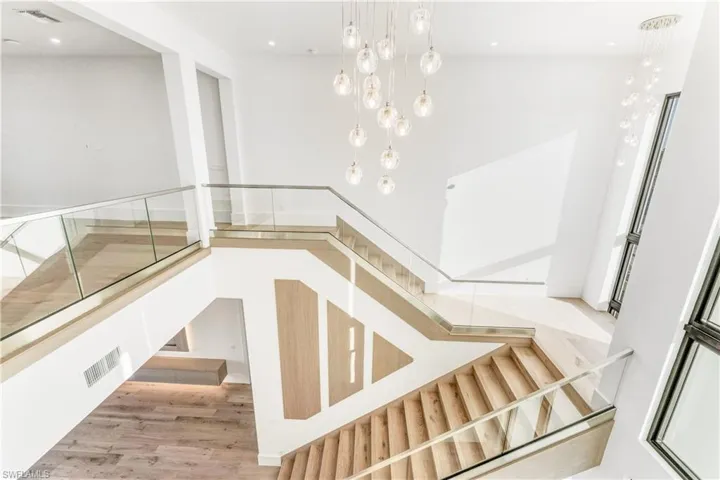 Stairs with wood finished floors and recessed lighting