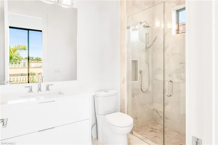 Full bathroom with vanity and a marble finish shower