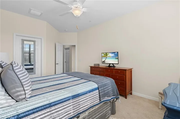 Bedroom with ceiling fan and light colored carpet