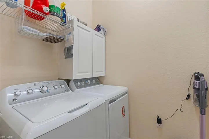 Washroom featuring cabinets and independent washer and dryer
