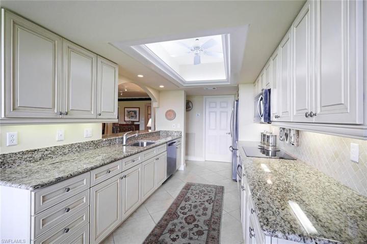 White cabinetry, granite countertops, tile backsplash, tons of storage space and stainless appliances. There is a large pantry/utility room across from the kitchen.