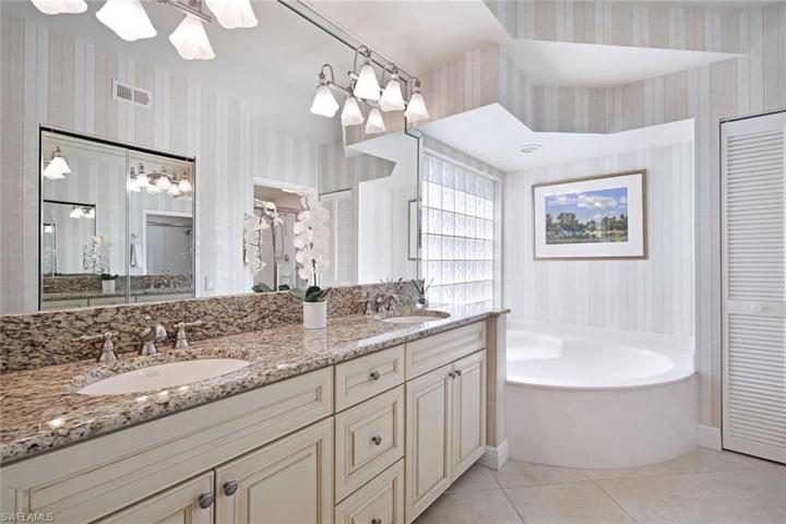 En suite primary bath with dual sinks, soaking tub and walk in shower.
