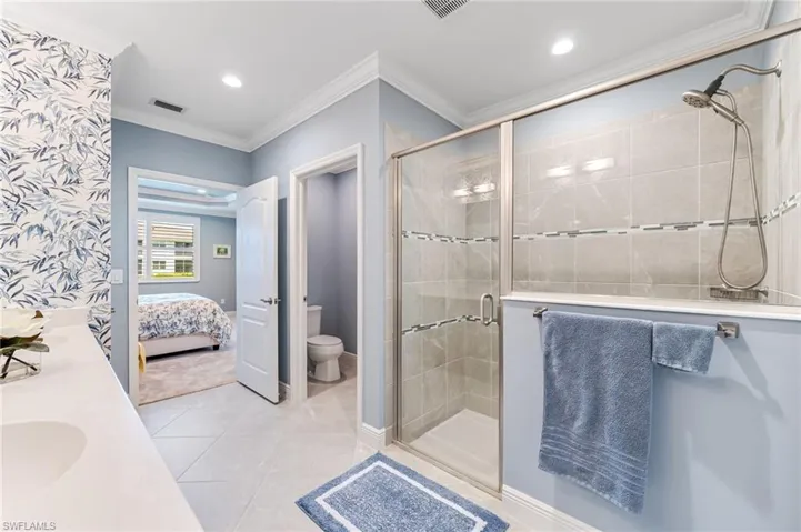 Ensuite bathroom with crown molding, a shower stall, visible vents, recessed lighting, and toilet