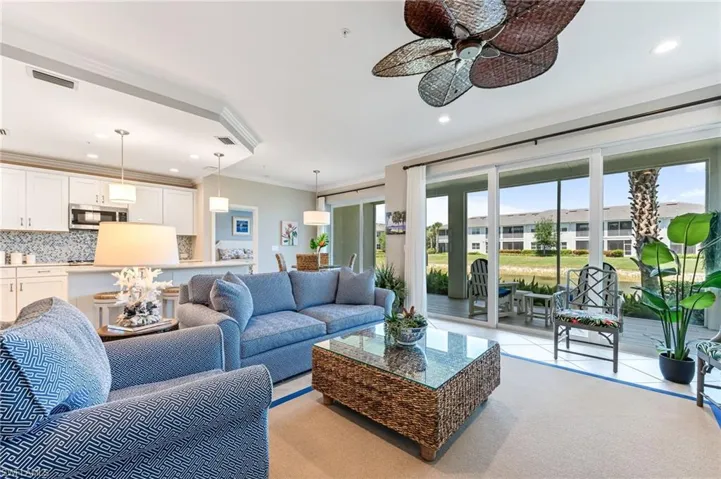 Living area featuring recessed lighting, visible vents, ornamental molding, and a ceiling fan