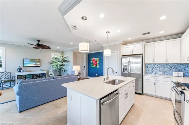 Kitchen featuring a sink, appliances with stainless steel finishes, crown molding, and a healthy amount of sunlight