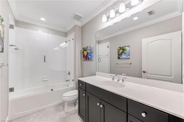 Full bathroom featuring toilet, crown molding, vanity, and visible vents