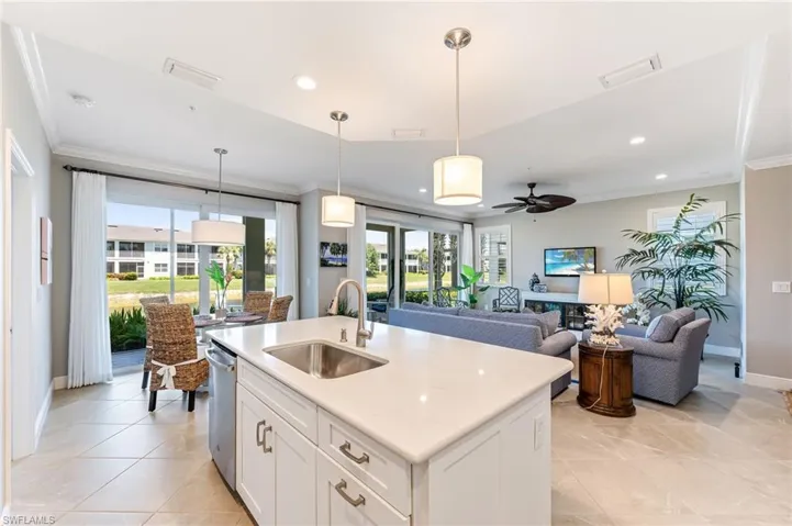 Kitchen featuring a sink, visible vents, a ceiling fan, and crown molding