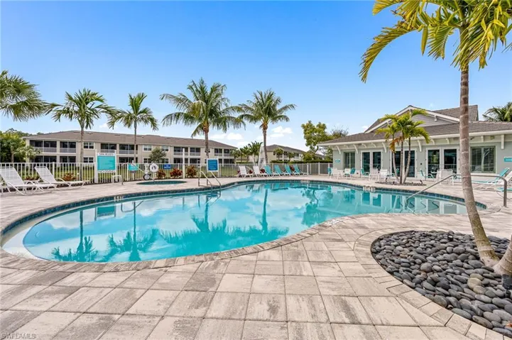 Community pool with a patio area and fence