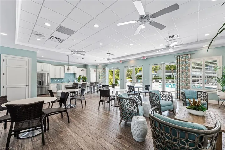 Dining room with visible vents, ceiling fan, a drop ceiling, and wood finished floors