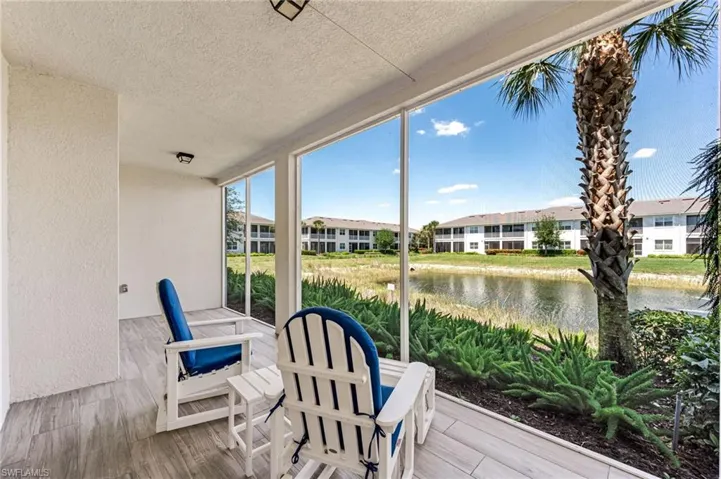 Sunroom with a water view and a residential view