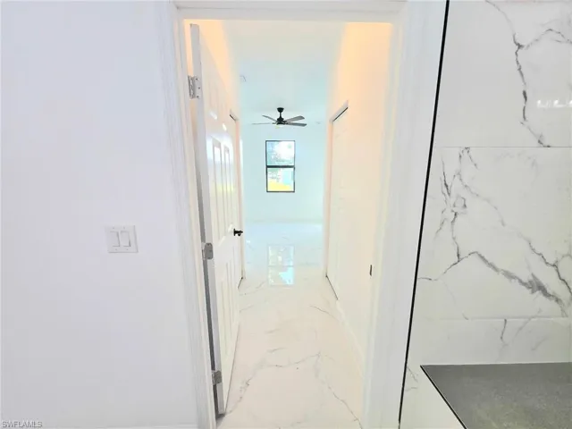 Hall featuring light marble finish flooring