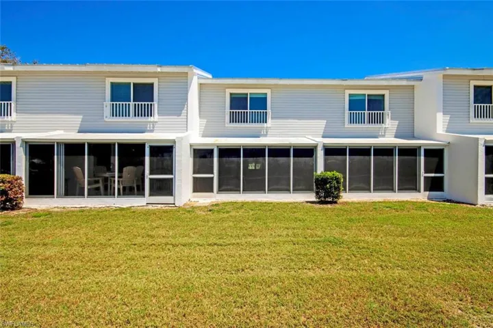 Rear view of property with a sunroom and a yard