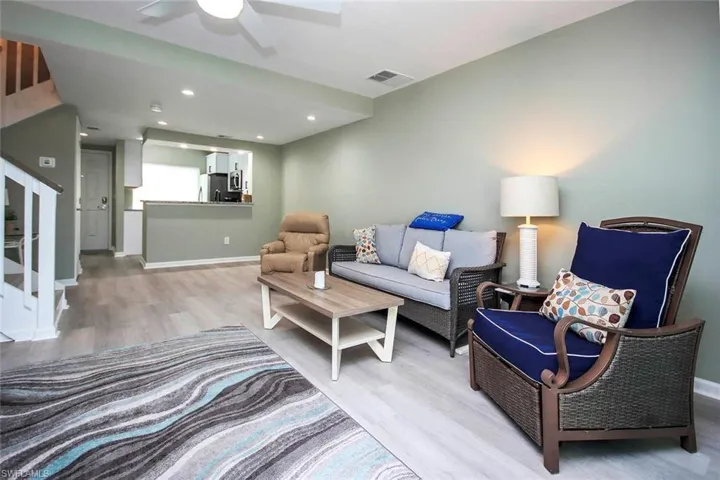 Living area featuring light wood-type flooring, ceiling fan, baseboards, and visible vents