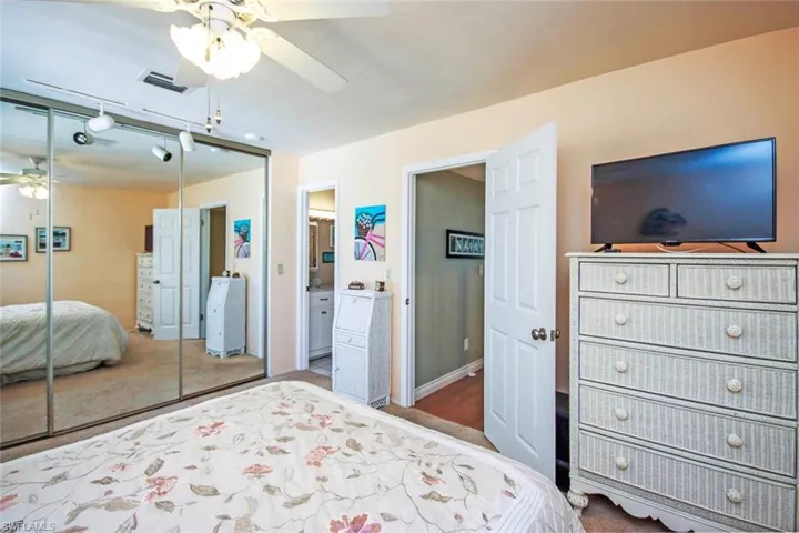 Bedroom with visible vents, a closet, a ceiling fan, carpet, and connected bathroom