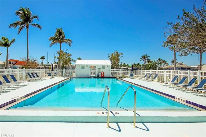 Pool with a patio, fence, and an outdoor structure