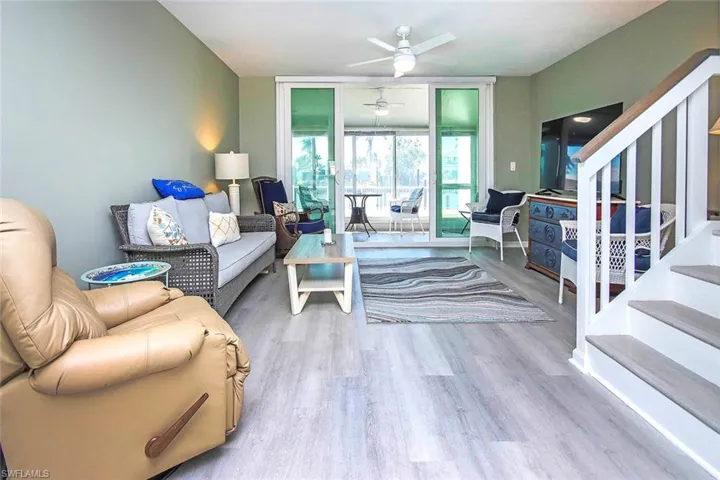 Living area featuring stairway, a ceiling fan, and wood finished floors
