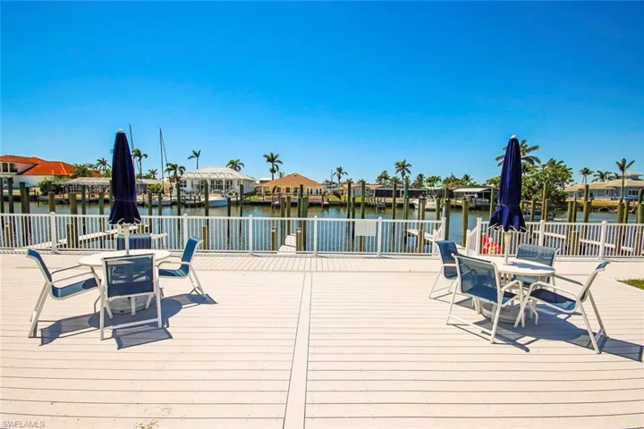 Dock area with a deck with water view, outdoor dining space, and a residential view