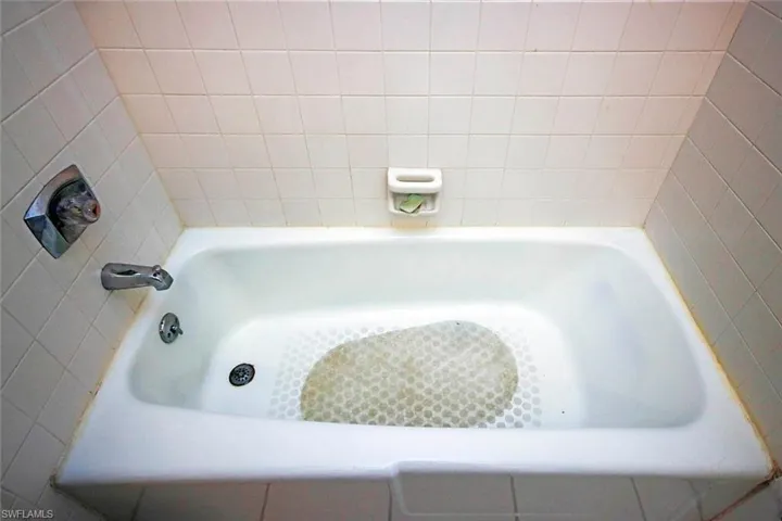 Full bath with a shower and a washtub