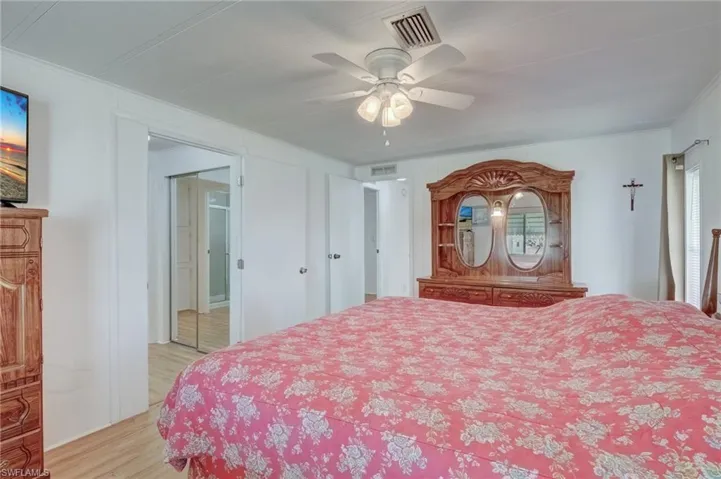 Bedroom featuring light wood-type flooring, a ceiling fan, and ornamental molding
