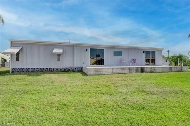 Back of property featuring a lawn