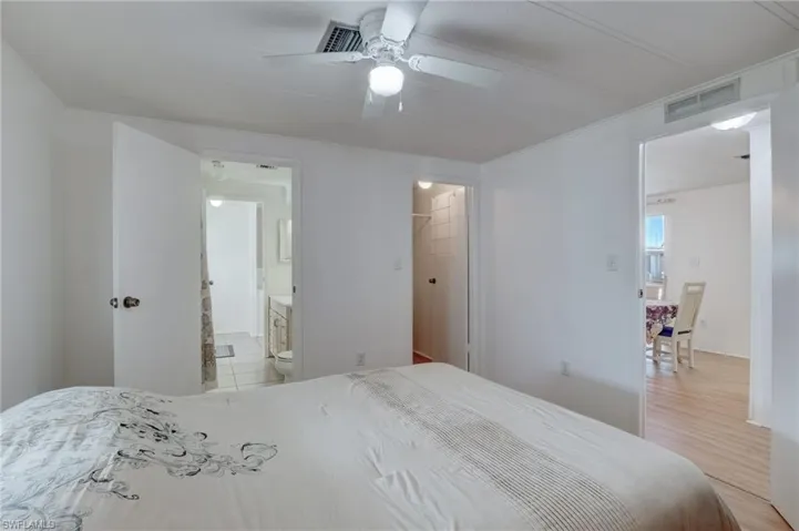Bedroom with a walk in closet, a ceiling fan, and crown molding