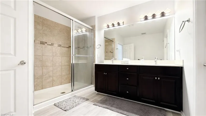 Bathroom with double vanity and a stall shower