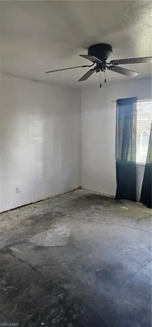 Empty room featuring unfinished concrete flooring and ceiling fan