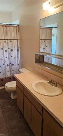 Bathroom with vanity, tile patterned floors, and a shower with shower curtain