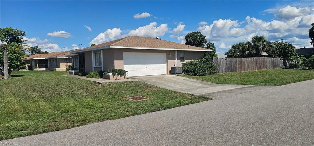 View of side of property featuring stucco siding, a garage, and concrete driveway