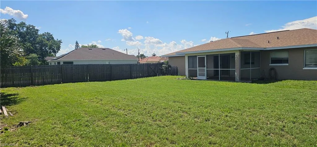 Fenced backyard with a sunroom