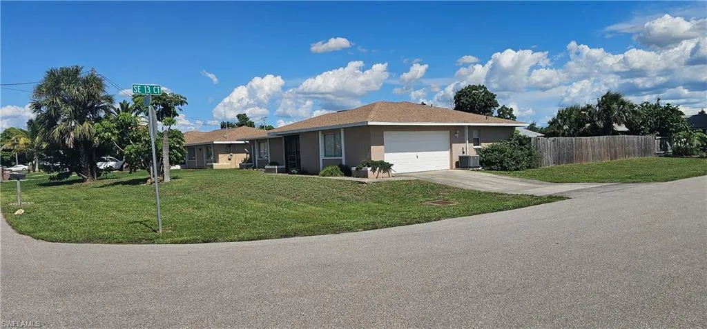 View of front of home with an attached garage, driveway, and stucco siding